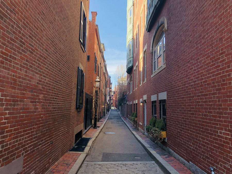 A narrow brick lane between old row houses