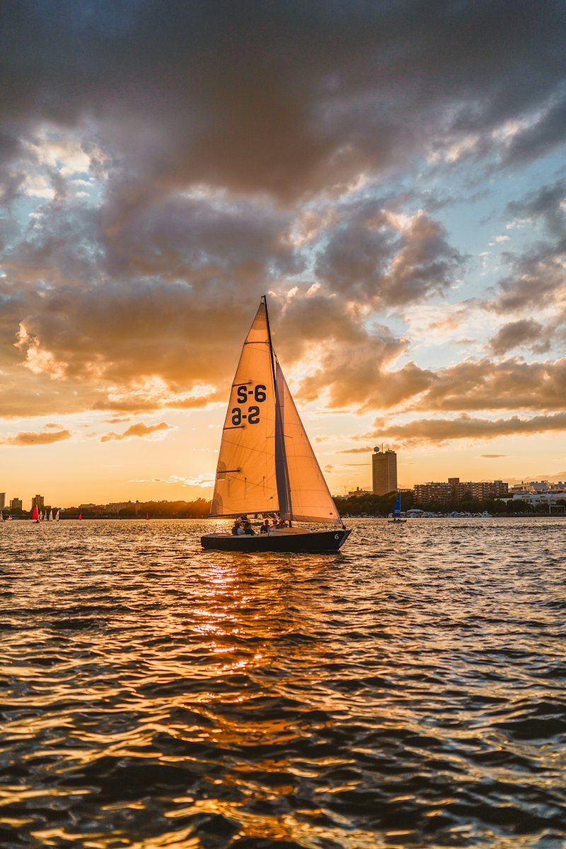 A sailboat on the Charles River at sunset